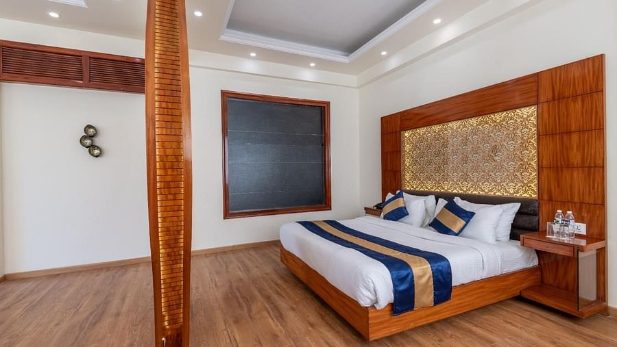 Image of the hotel bedroom with a king size bed and wooden furnishing  | DLS Serenity Resort and Spa